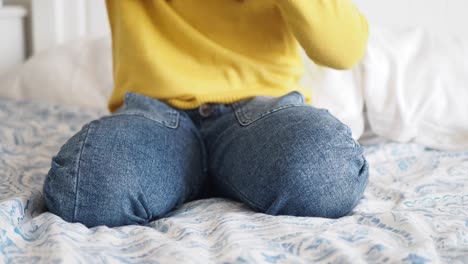 a young girl sitting on a bed, smiling and looking happy