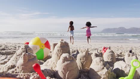 hermano y hermana afroamericanos corriendo hacia el mar en la playa