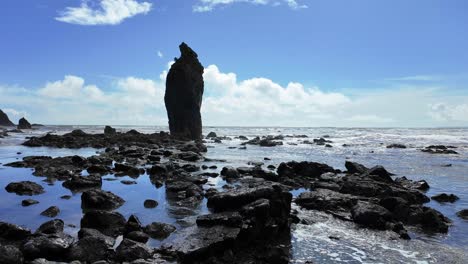 Spring-tides-gently-filling-stony-beach-under-large-sea-stack-at-Ballydwane-Beach-in-Waterford-Ireland