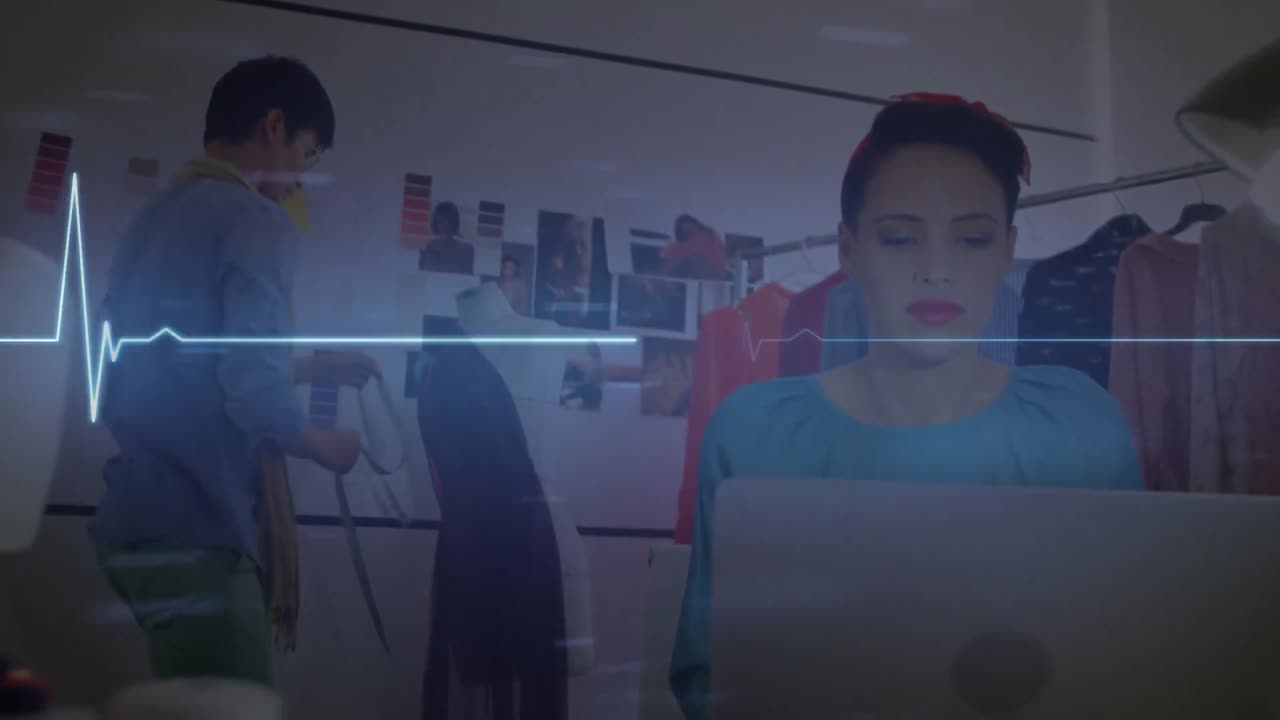 animación de un monitor de ritmo cardíaco brillante, sobre una mujer que usa una computadora portátil en una oficina creativa