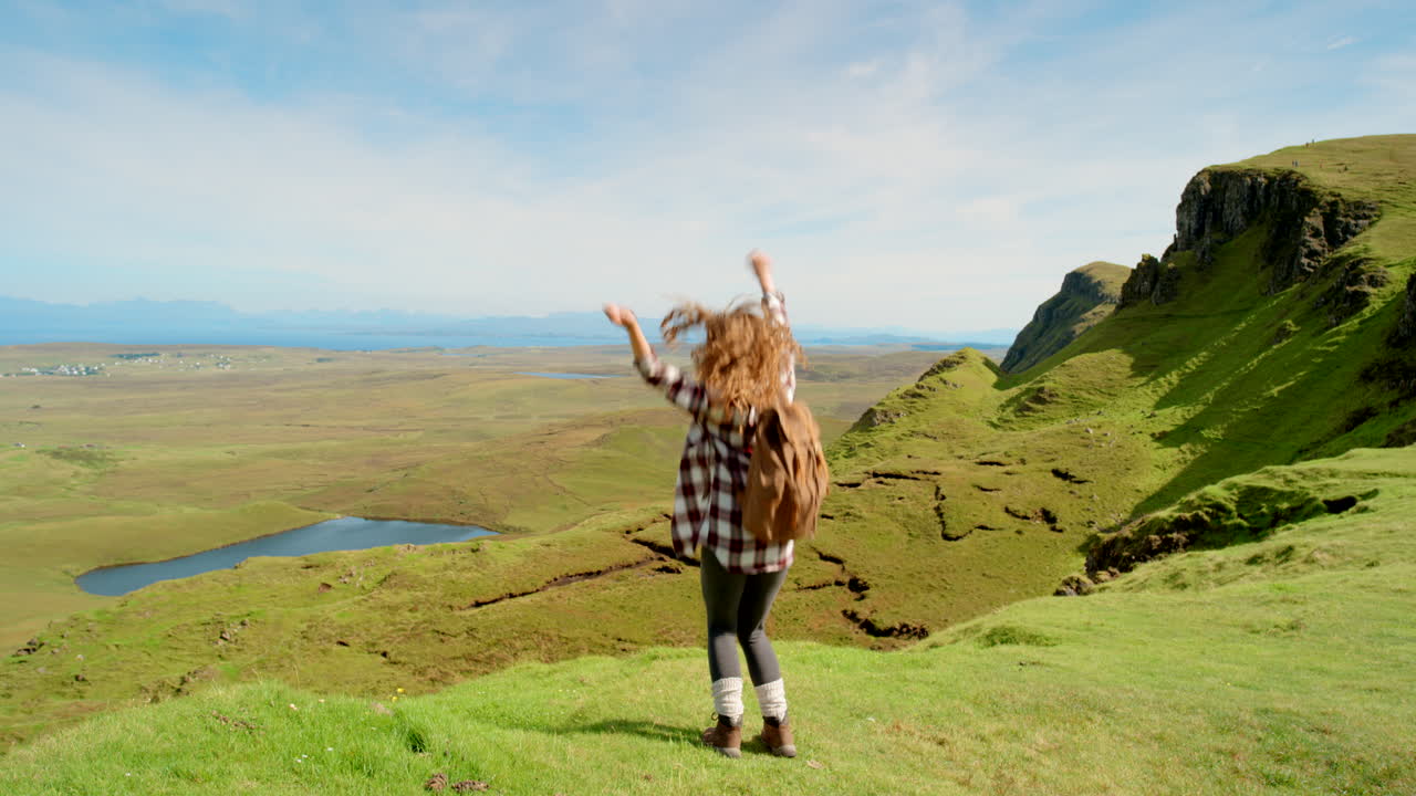 mujer feliz haciendo senderismo en escocia