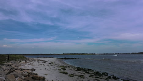 Eine-Drohnenaufnahme-Aus-Einem-Niedrigen-Winkel-Von-Einem-Leeren-Strand-An-Einem-Sonnigen-Tag