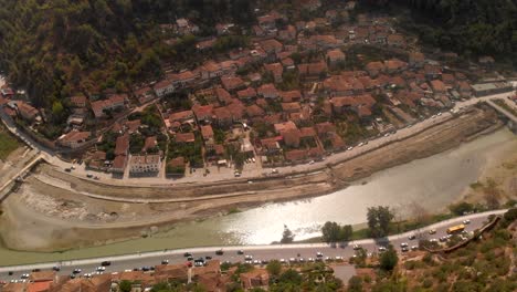 Slow-aerial-tilt-up-from-Albanian-flag-to-Berat-City-on-clear-day