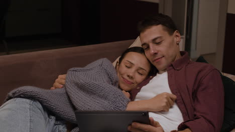 couple relaxing on couch and watching movie/show