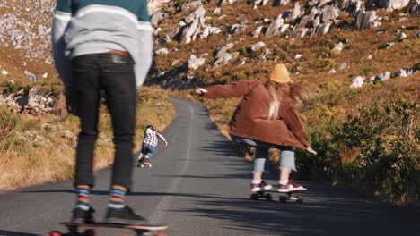 young multi ethnic friends longboarding together riding skateboard cruising downhill on countryside road having fun enjoying relaxed summer vacation