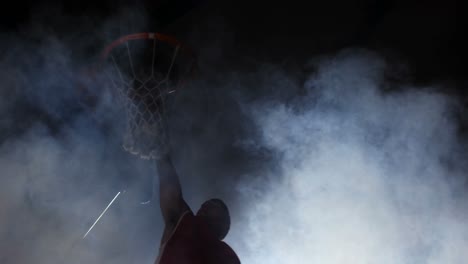 sportsman dunking basketball in hoop