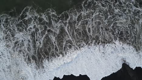 Top-down-shot-of-waves-crashing-in-the-south-of-Bali,-aerial