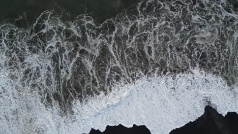 top down shot of waves crashing in the south of bali, aerial