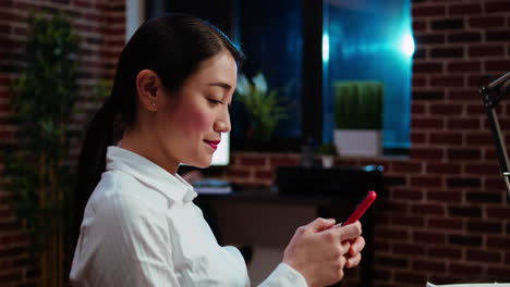 analista financiero mirando mensajes de texto en su teléfono inteligente, tomando un descanso del trabajo