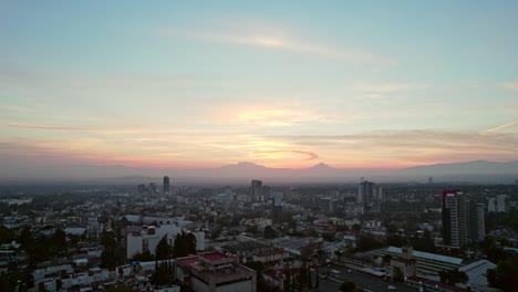 Amanecer-En-La-Ciudad-Con-Un-Hermoso-Cielo-Rojo-Con-Volvanes-En-El-Fondo