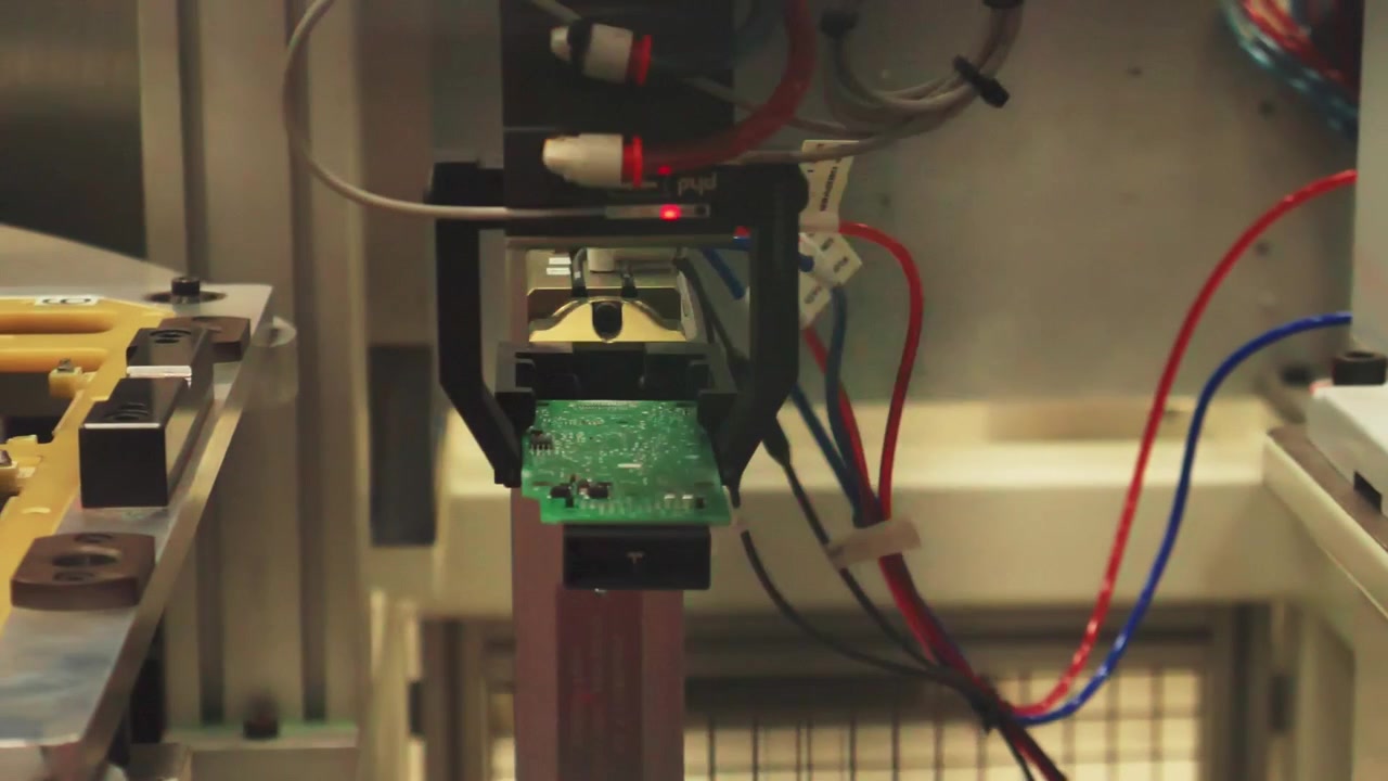 Robotic machine handles semiconductor at vehicle technology plant, close pan