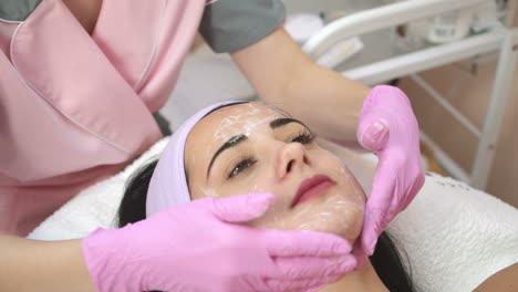 beautiful young woman receiving massage in spa salon. face cosmetic procedure.