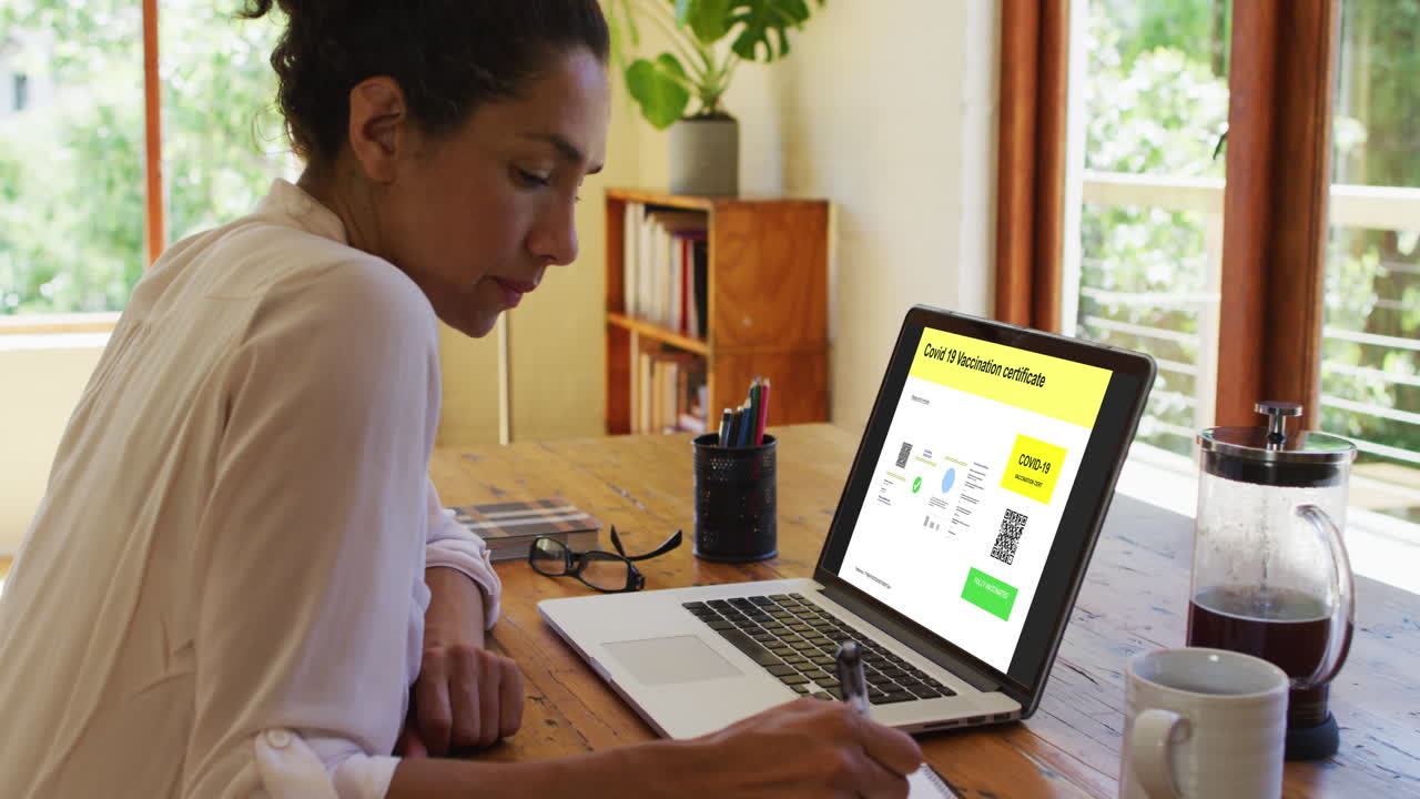 Woman working at desk, covid vaccination certificate with qr code on laptop screen