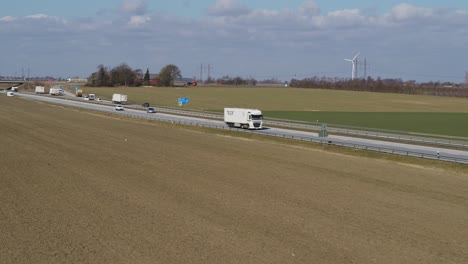 Los-Drones-Vuelan-Sobre-Un-Campo-Junto-A-Una-Autopista-Con-Tráfico-En-Primavera