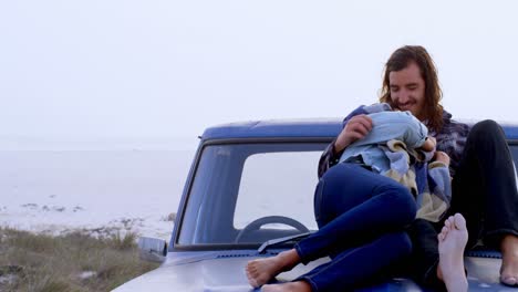 couple embracing each other on car bonnet 4k