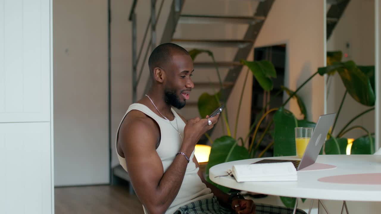 hombre usando un teléfono inteligente y una computadora portátil en casa