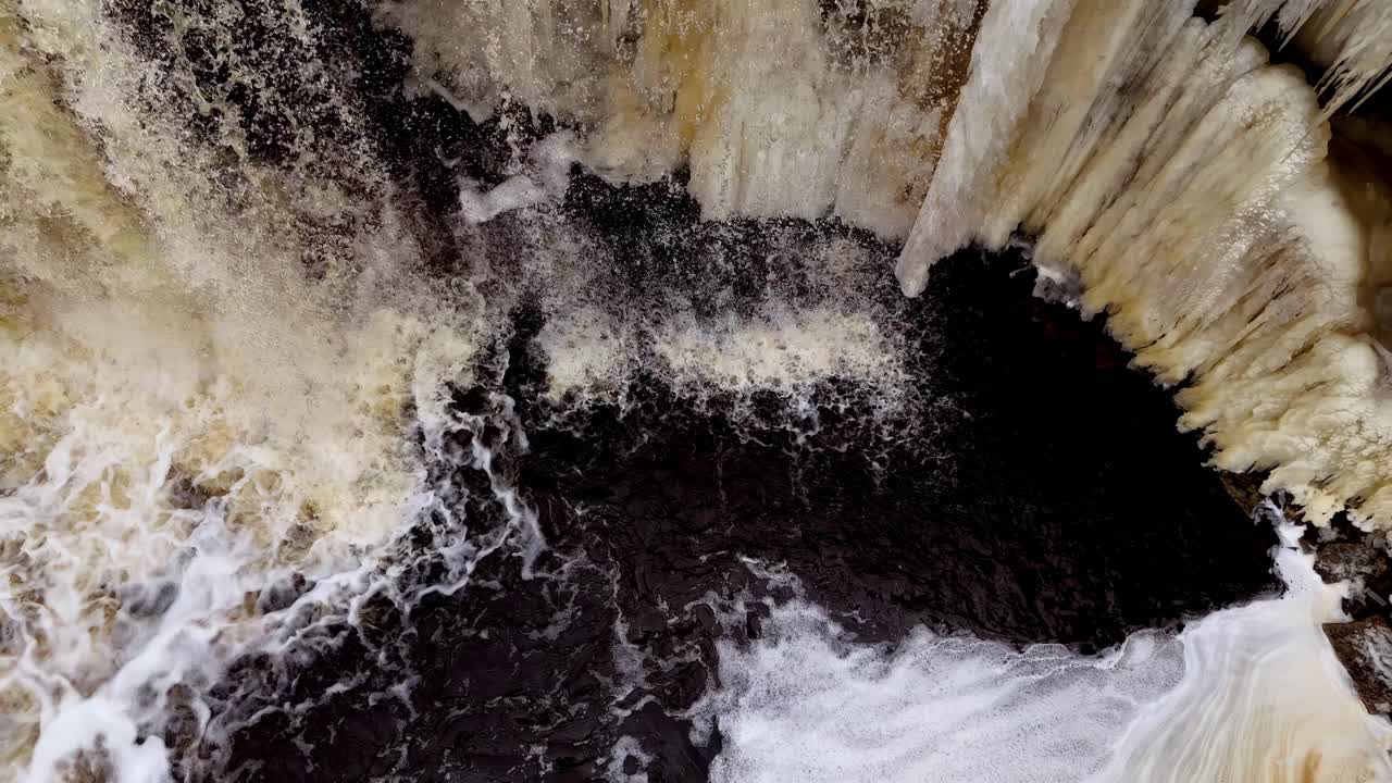 drones que fluyen agua que cae de una cascada de gran altitud en estonia