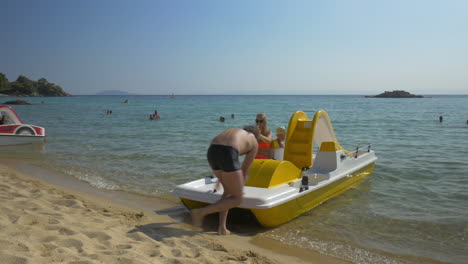 family sailing on pedal boat in the sea