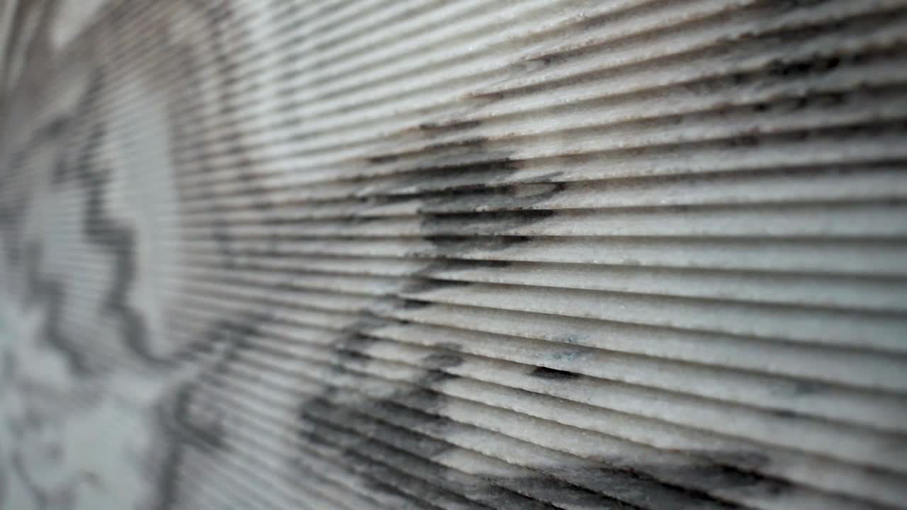 Close-up of cut lines on a marble slab after industrial sawing. Sharp grooves and stone texture visible. Marble cutting pattern, stone processing detail, construction, and granite surface texture