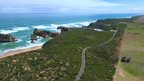 video de avión no tripulado de 4k siguiendo a lo largo de la camioneta que está conduciendo a lo largo del gran camino del océano en victoria, australia