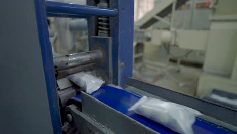 soap bars being sealed in packaging along conveyor belt in factory