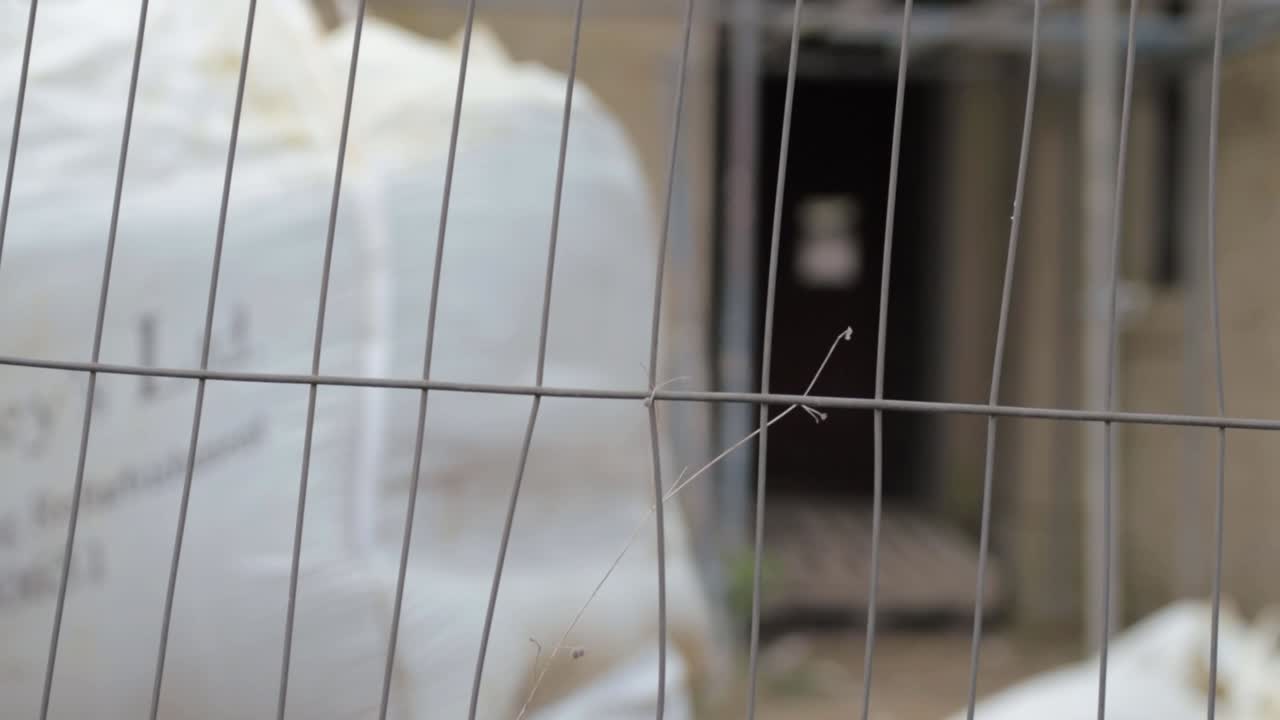 View of house building construction site through metal fence