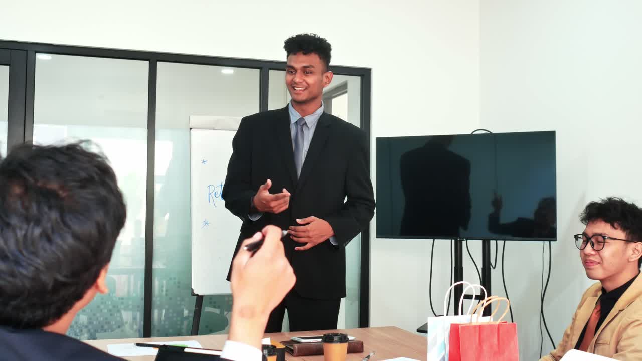 Confident young professional presenting business strategy to colleagues in modern meeting room