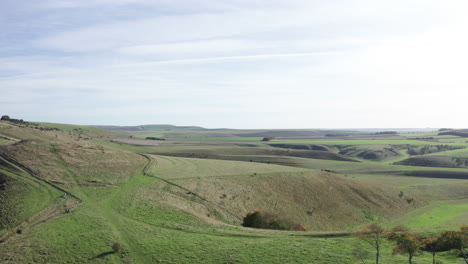 vista aérea de las colinas y los campos de la campiña inglesa, filmada en un brillante día de otoño con cielos azules brillantes