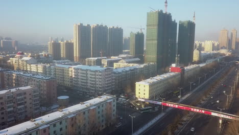 Aerial-descends-to-apartment-blocks-in-cold-winter-city,-Harbin-China