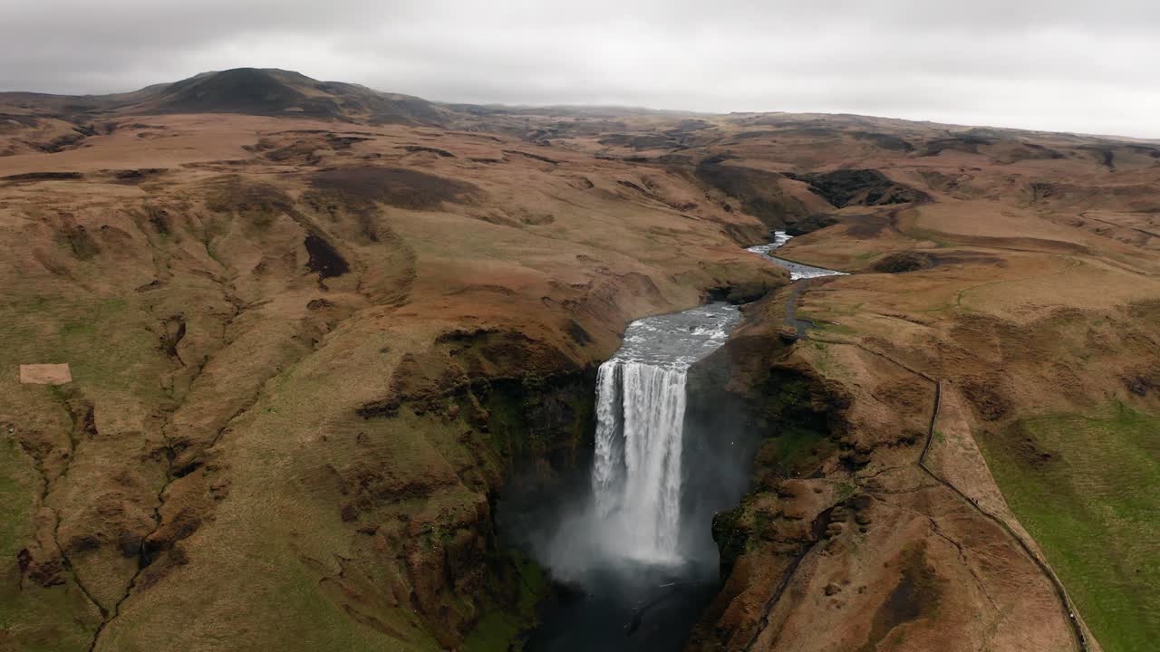 video de drones acercándose a la cascada skogafoss de islandia en invierno