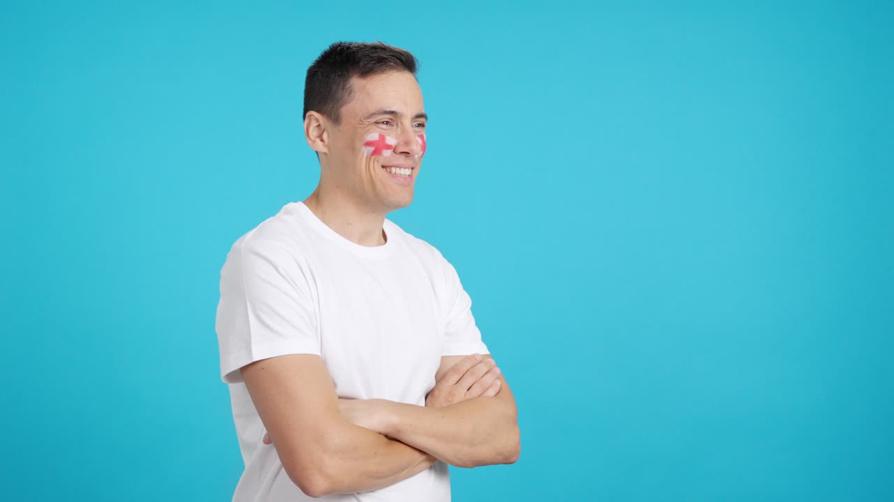 Happy man with english flag painted on face looking away