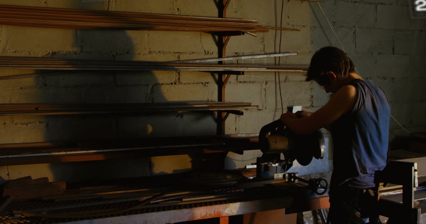 Metalworker placing rod on saw initiating sparks and animating timeline showing year progression