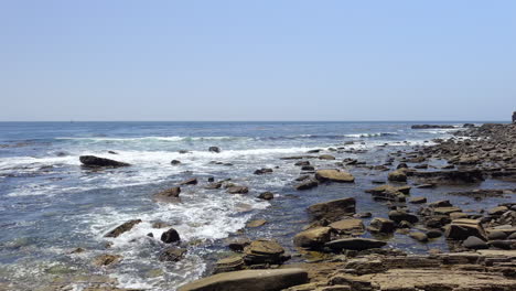 The-beach-below-the-cliffs-of-Sunken-City-in-coastal-San-Pedro,-California-where-houses-fell-into-the-ocean-in-a-landslide---low-altitude-aerial-flyover