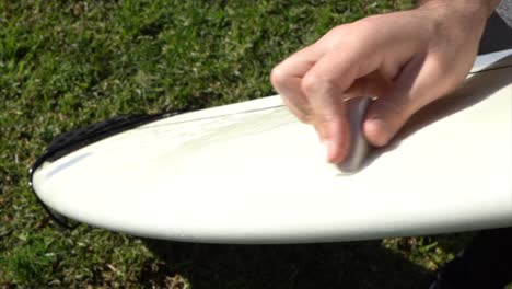 Surfer-putting-wax-on-his-surfboard