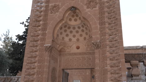 vemos la entrada principal del jardín hecha de piedra rosa de la mezquita latifiye de mardin