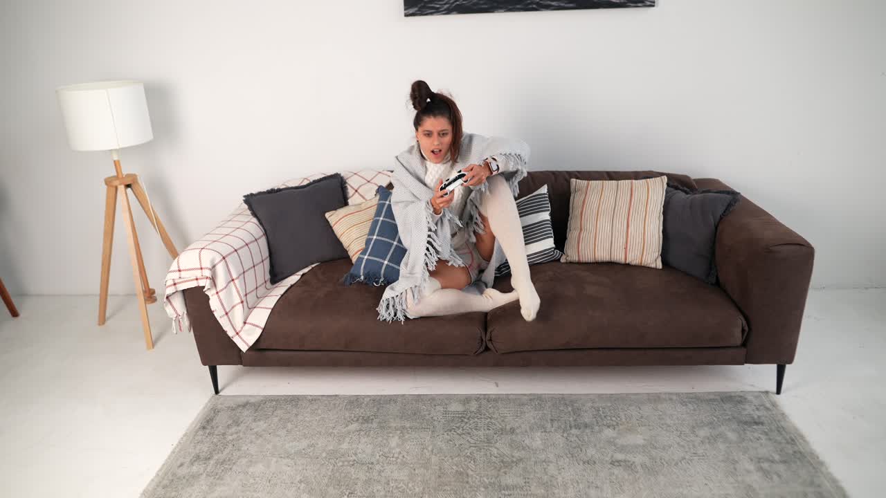 mujer jugando videojuegos en un sofá