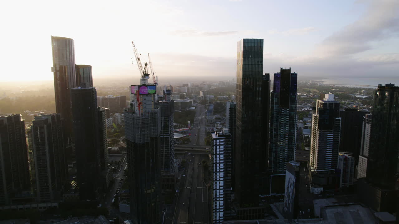 AERIAL: Traffic on the State Route 50 between high-rise of Melbourne, sunrise