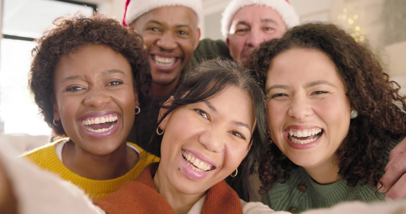Grupo diverso de amigos tomándose una selfie en una fiesta de Navidad.