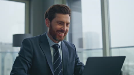 smiling man working laptop at luxury workplace closeup. startuper drinking tea