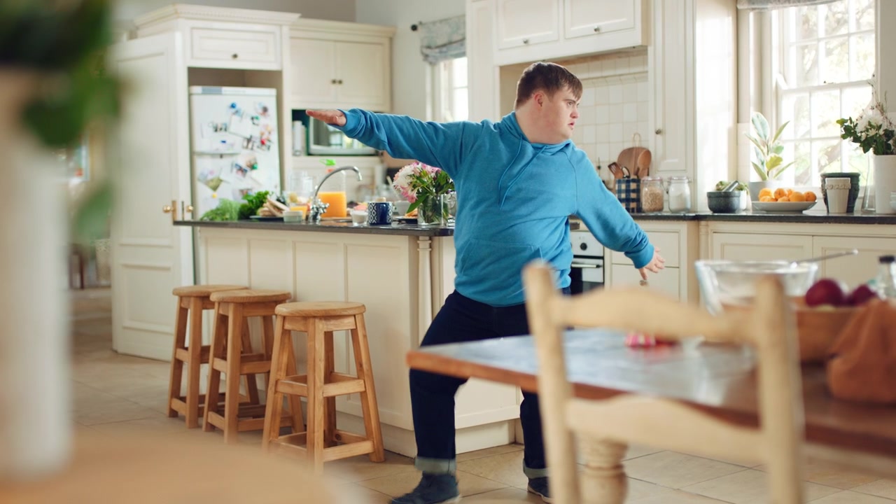 Young Man with Down Syndrome Dancing Energetically in Kitchen