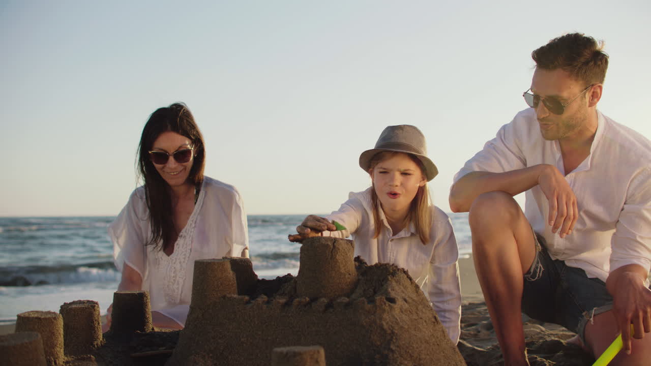 семья строит песчаные замки на пляже
