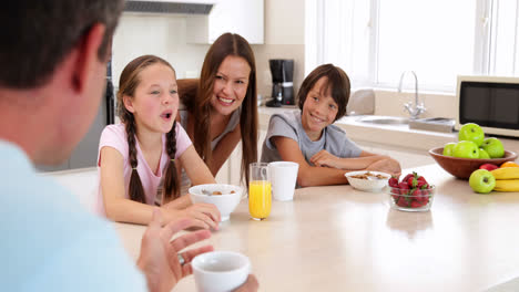 familia feliz desayunando juntos