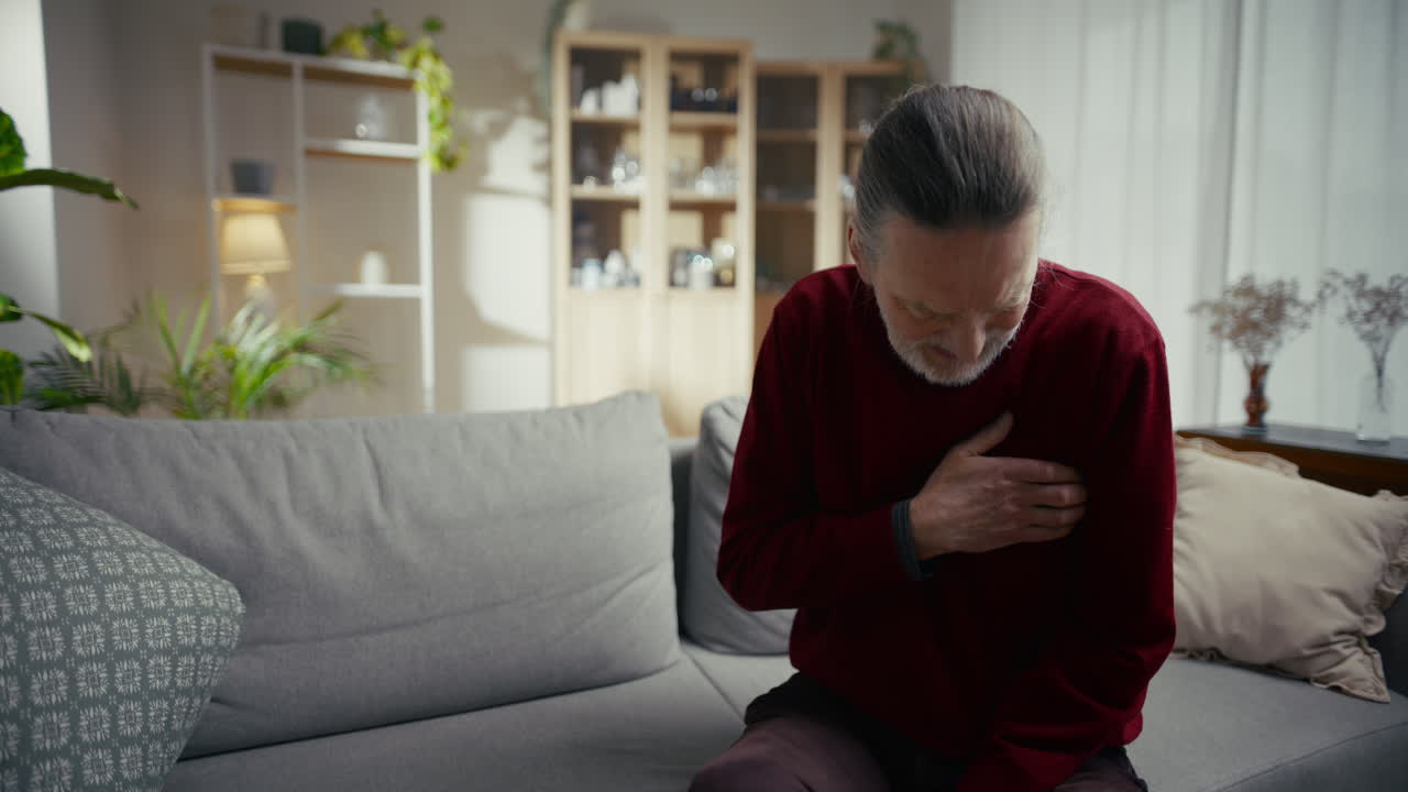 Elderly Man Experiences Sudden Chest Pain While Sitting on Sofa