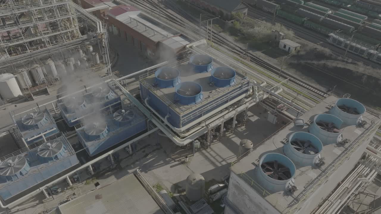 Aerial View of an Industrial Plant with Cooling Towers and Train Tracks