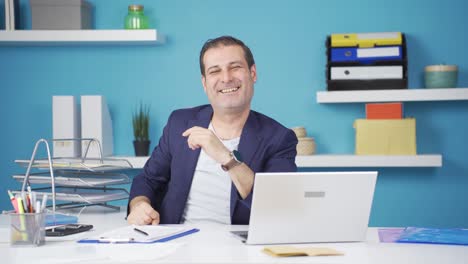 loving businessman making heart symbol at camera.