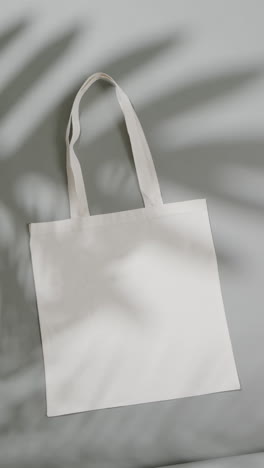 vertical video of high angle view of white canvas bags with copy space on white background