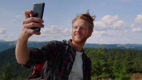 hiker taking selfie photo on smartphone in mountains