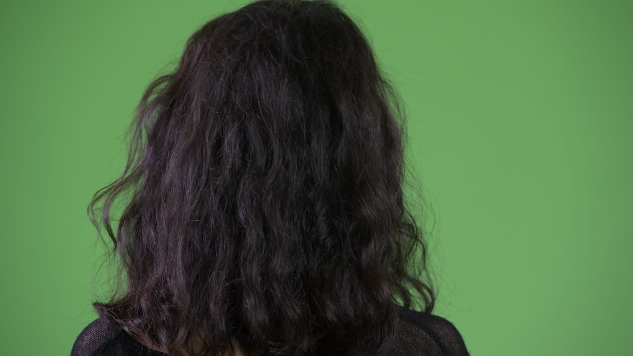 Rear view of young beautiful woman looking for something