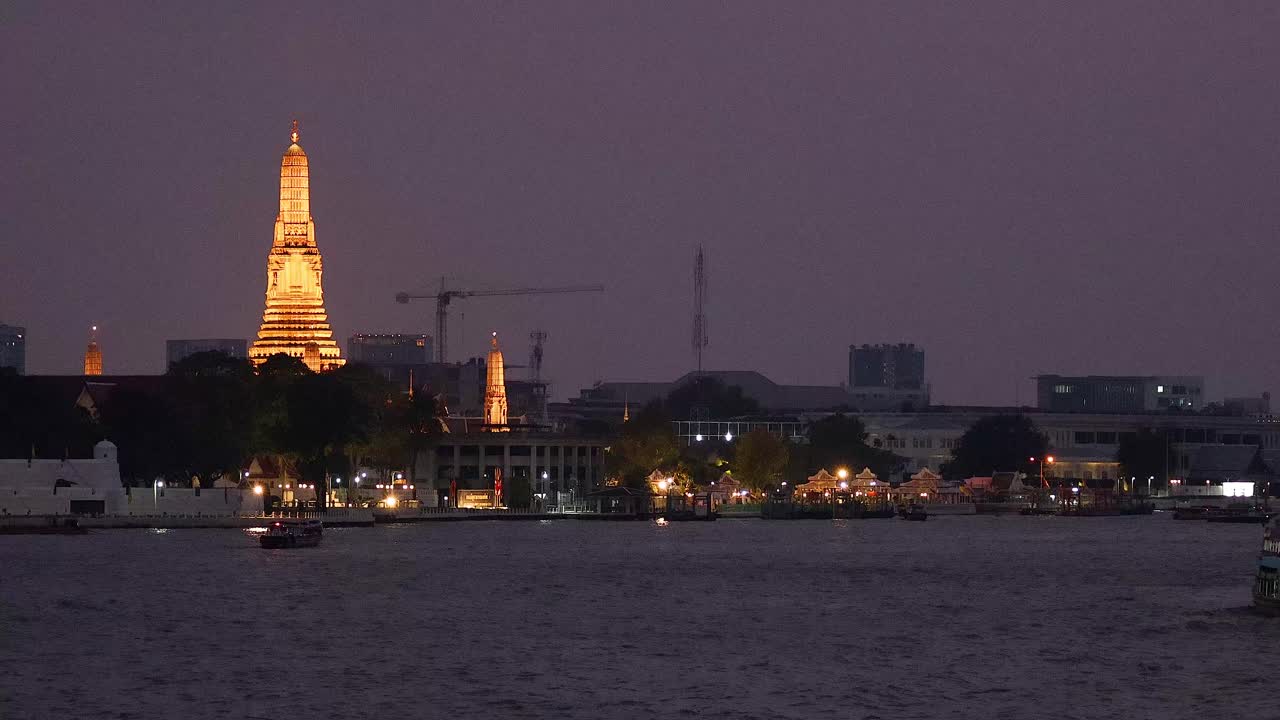Illuminated temple by river during evening