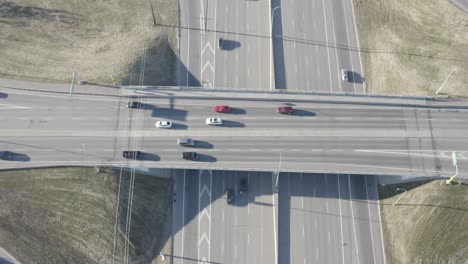 Luftdrohne-Aus-Der-Vogelperspektive-Auf-Eine-Autobahnüberführungsbrücke-Mit-Stetigem-Verkehr-Von-Vorbeifahrenden-Fahrzeugen-An-Einem-Sonnigen-Sommertag-Mit-Kaum-Verkehr-Auf-Der-Fahrbahntrasse-Hoch-über-Der-Kreuzung-2-2